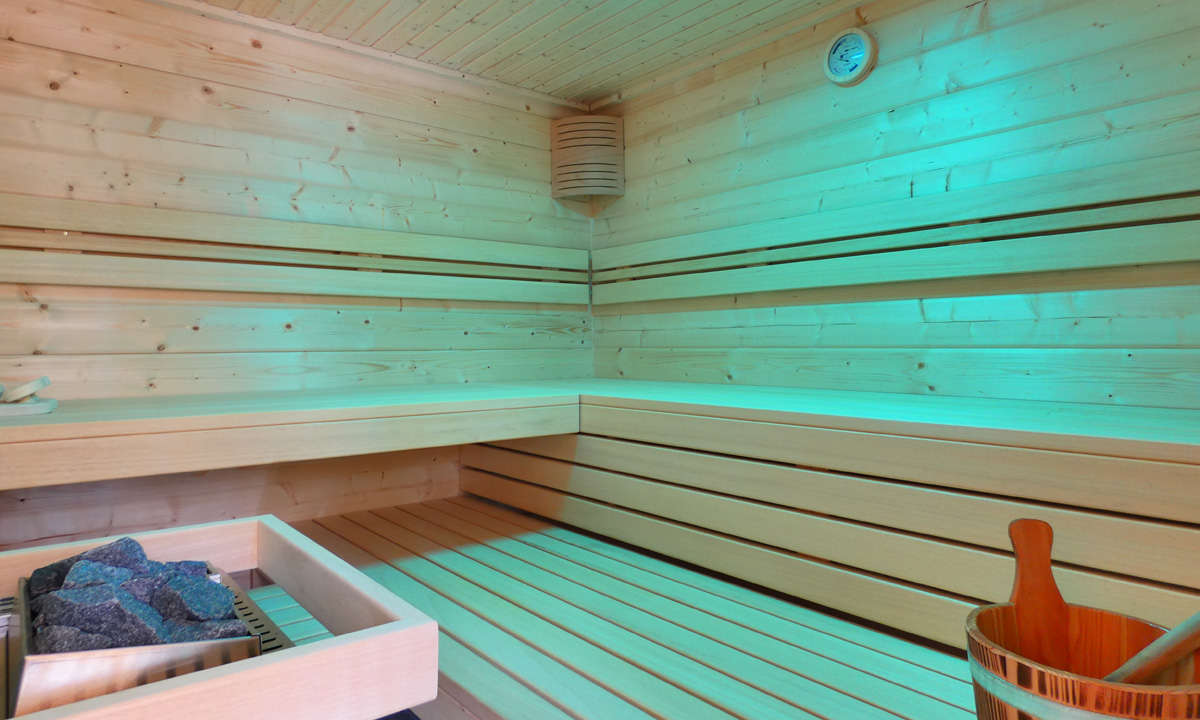 Sauna in Massivholz mit blauem Licht